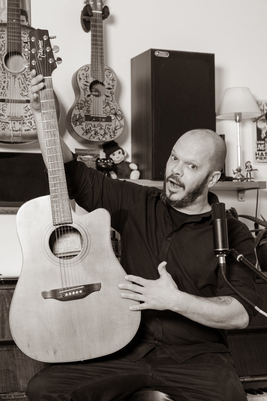 Seb Mallen, professeur de musique passionné avec sa guitare dans son studio